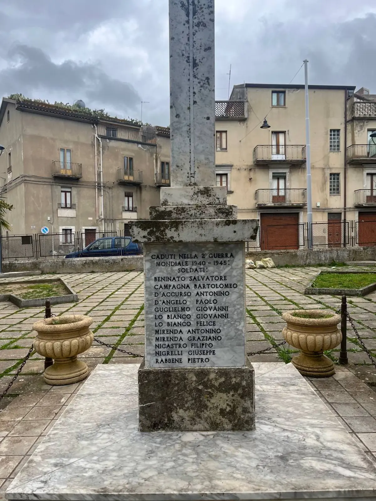 Monumento ai caduti di Sperlinga nella piazza principale con vista sul borgo e le montagne
